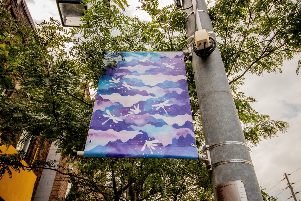 Photo of a street banner depicting waves and dragonflies